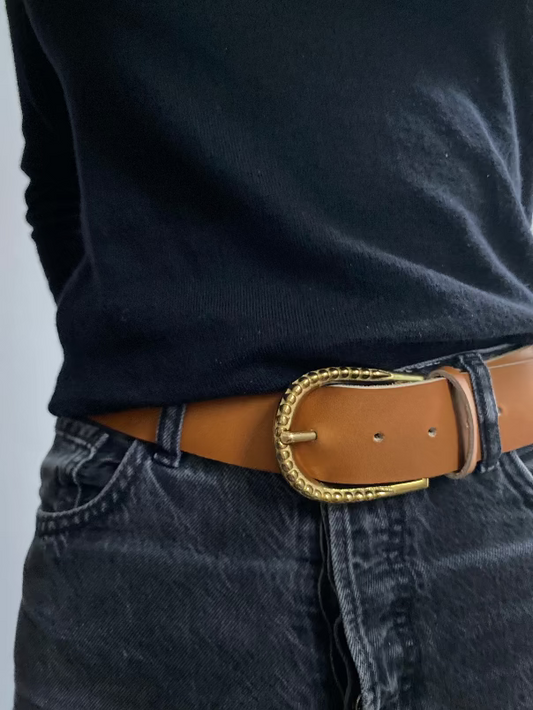 ceinture avec une grosse boucle dite perlée. Le cuir est de couleur naturel ; la ceinture fait 4 cm de large. Traverse est reconnu pour puiser ses matières premières dans un artisanat d'exception.