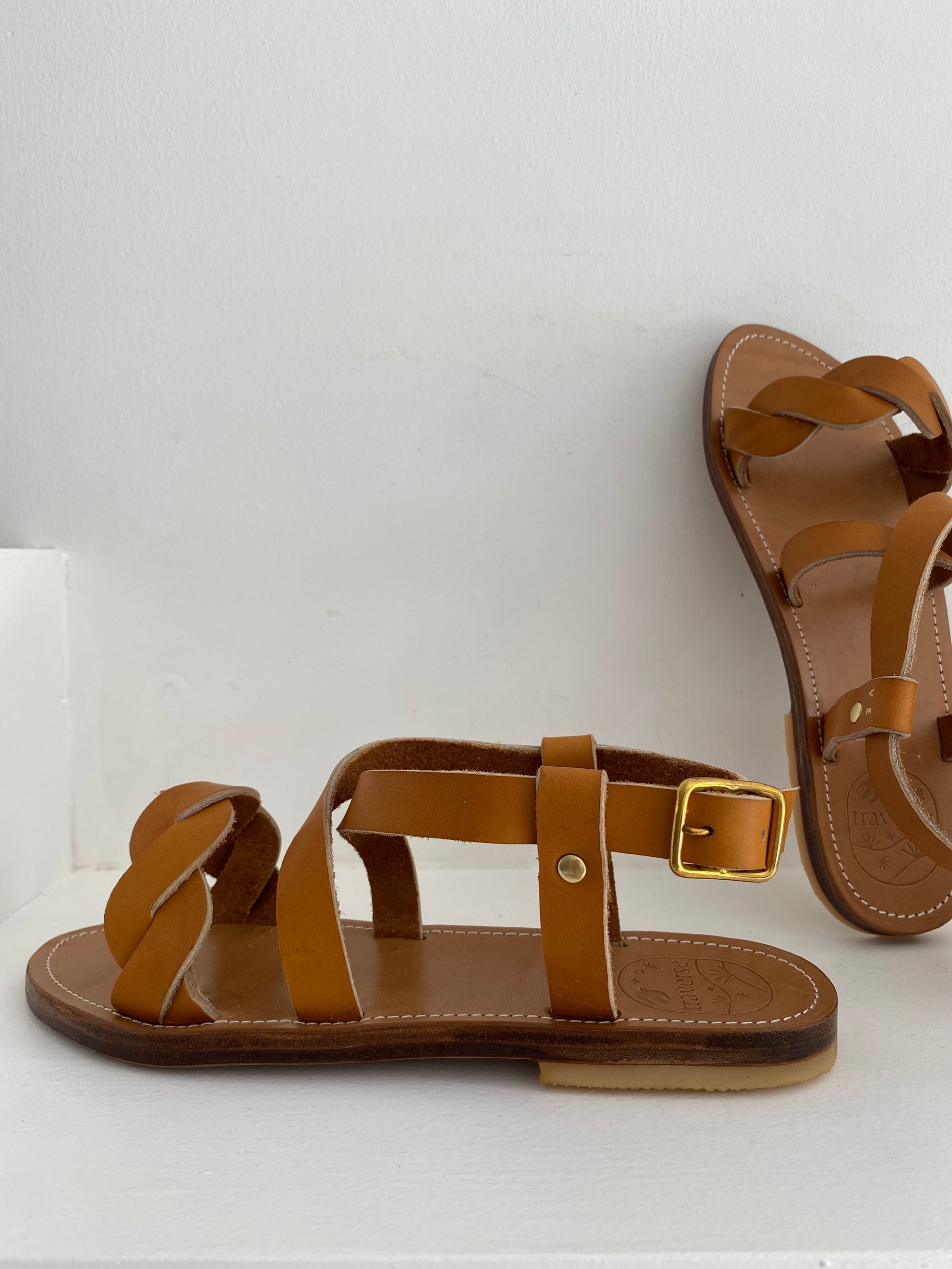 Nu-pieds TRAVERSE plats et confortables.

La tresse sur les orteils est particulièrement élégante et confortable.

La boucle autour de la cheville permet d'ajuster les sandales et le croisé sur le pied.

Ces nu-pieds sont fabriqués artisanalement, à la main, à Rennes avec des matières premières de grande qualité.