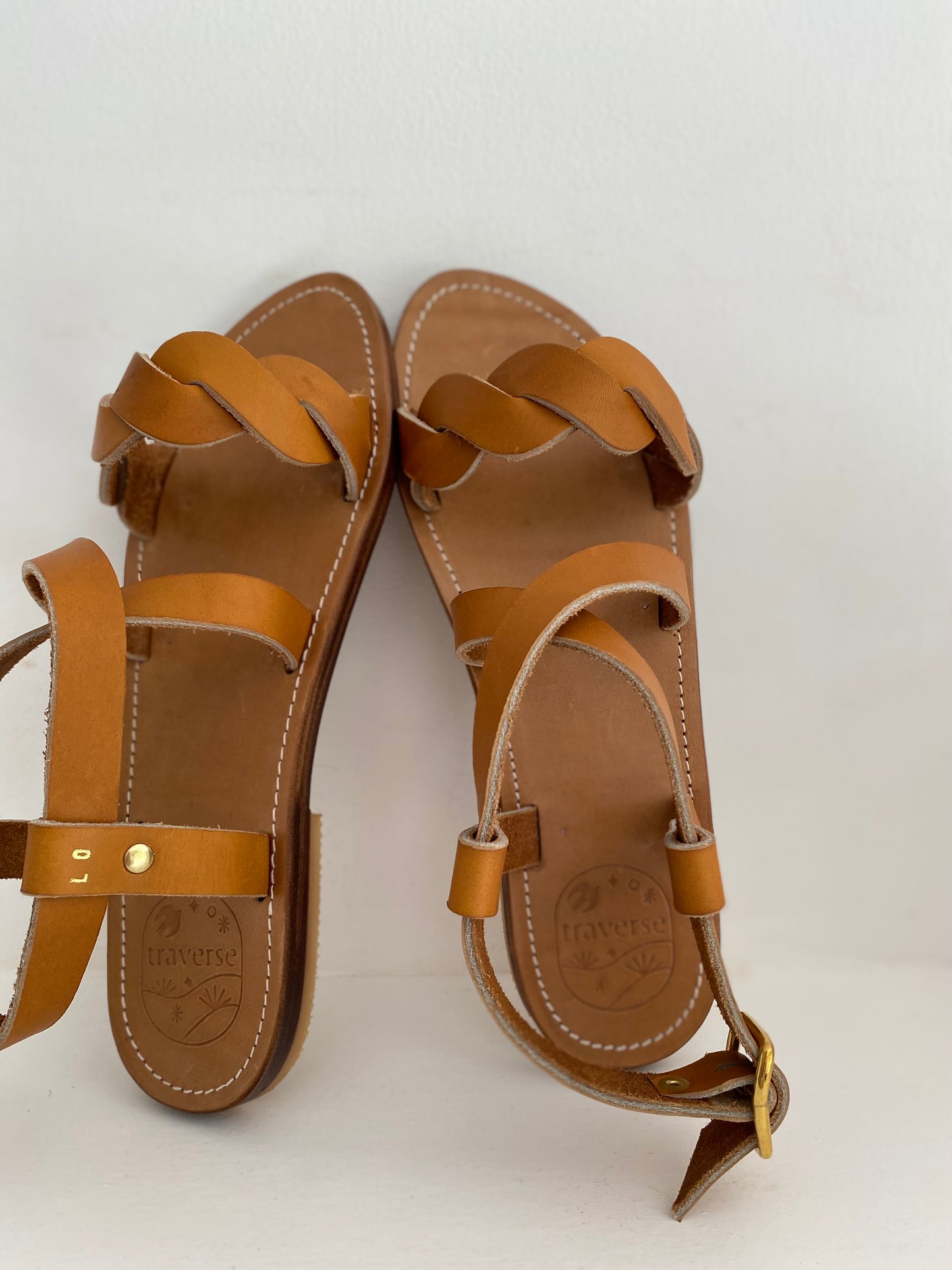 Nu-pieds TRAVERSE plats et confortables.

La tresse sur les orteils est particulièrement élégante et confortable.

La boucle autour de la cheville permet d'ajuster les sandales et le croisé sur le pied.

Ces nu-pieds sont fabriqués artisanalement, à la main, à Rennes avec des matières premières de grande qualité.