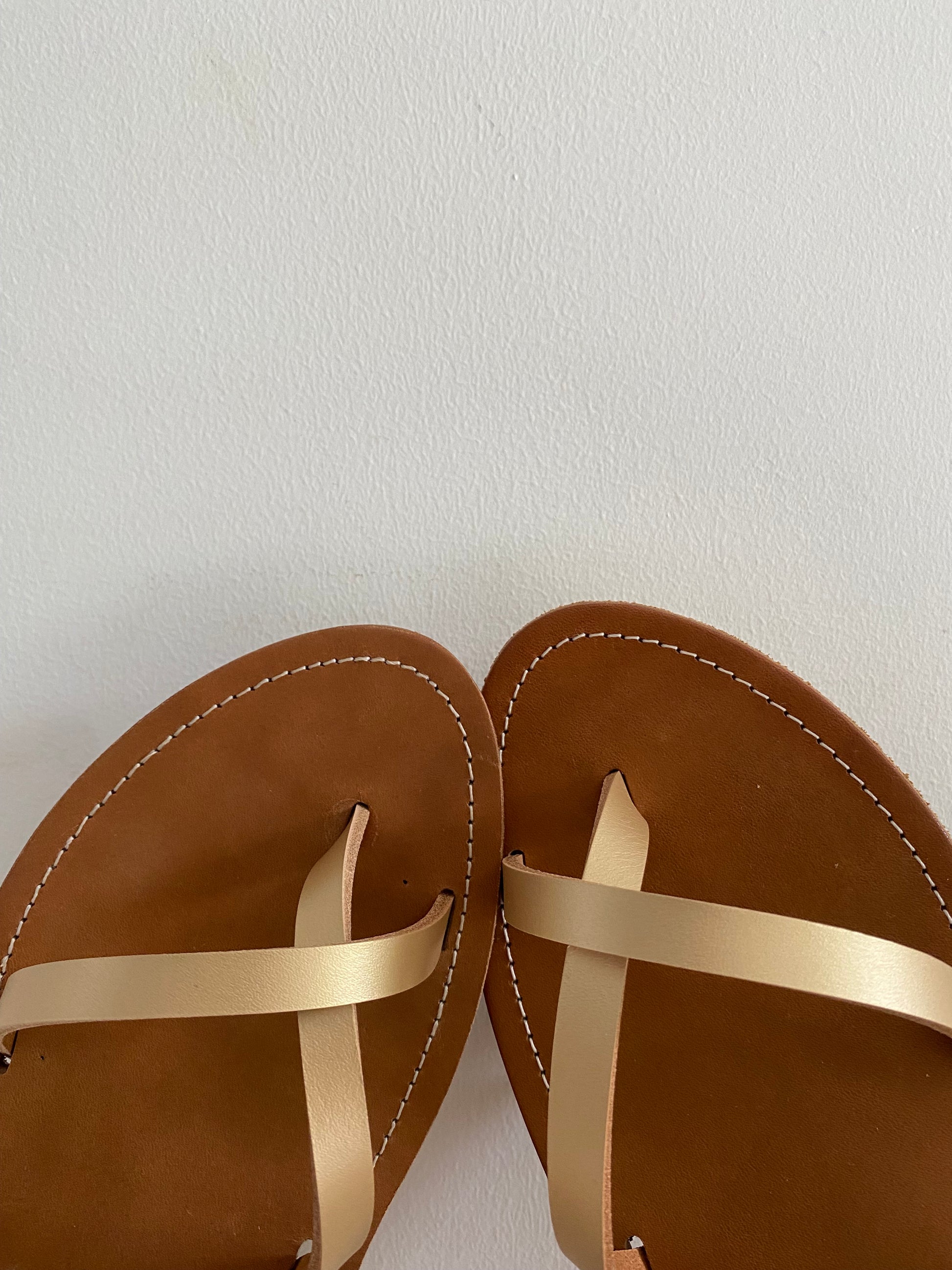 détail du croisé sur les orteils du modèle IDRIS en cuir doré ; ces nu-pieds  sont fabriqués par l'atelier TRAVERSE